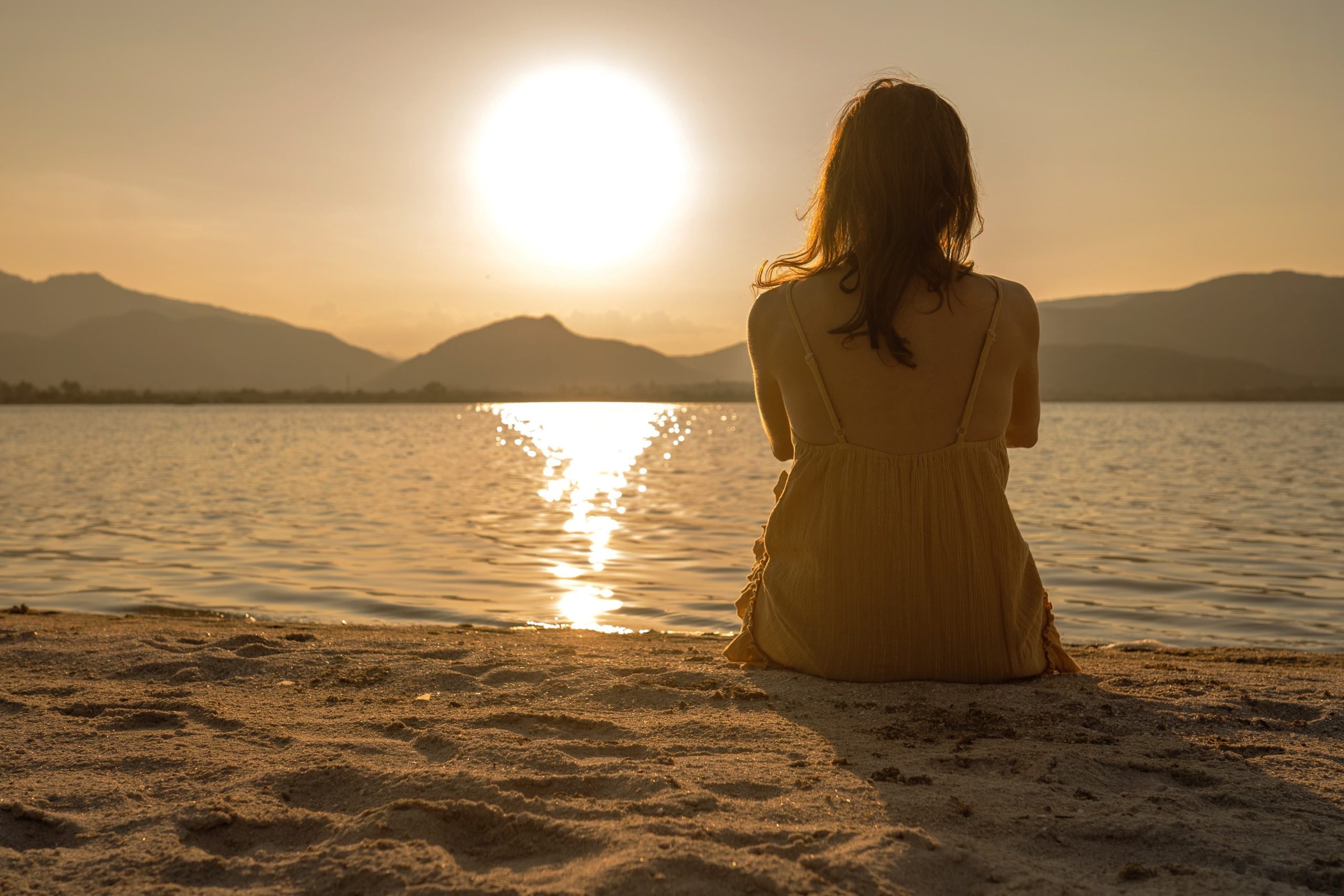 Mujer sentada mirando el atardecer